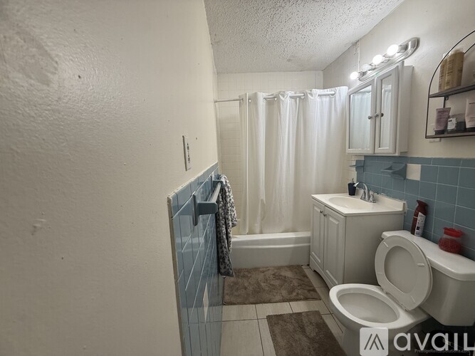 A bathroom with a toilet, sink, and shower.