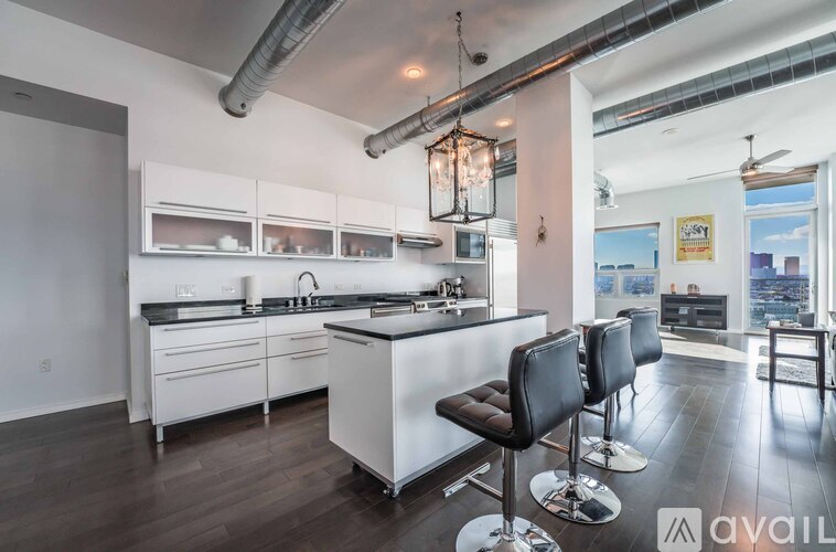 A modern kitchen with white cabinets and a black bar stool.