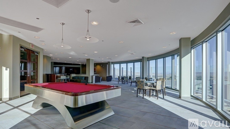 A pool table in a room with a glass wall.