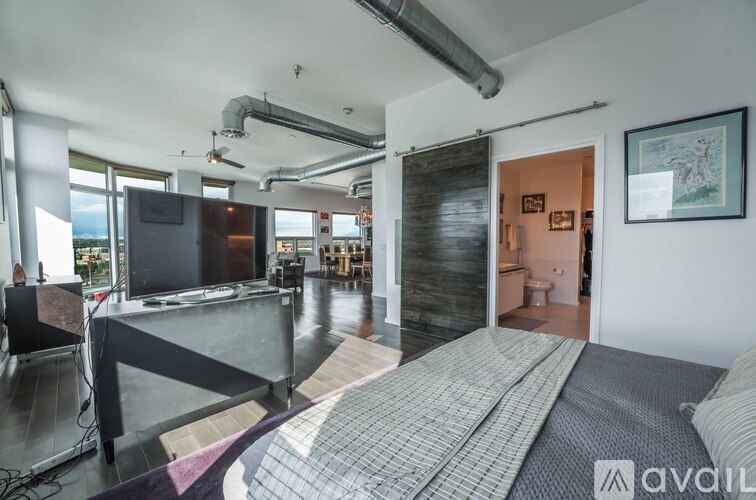 A bedroom with a large bed and a television in the living room.