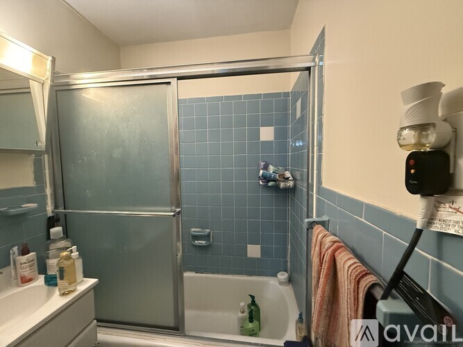 A bathroom with a glass shower door and a white bathtub.