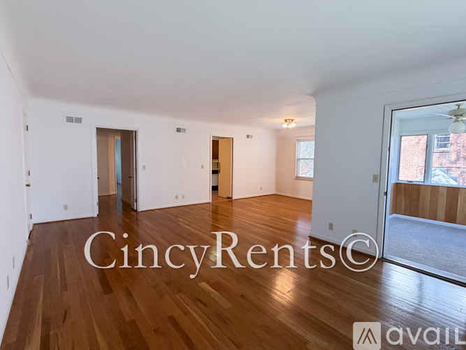 A large empty room with wooden floors and white walls.