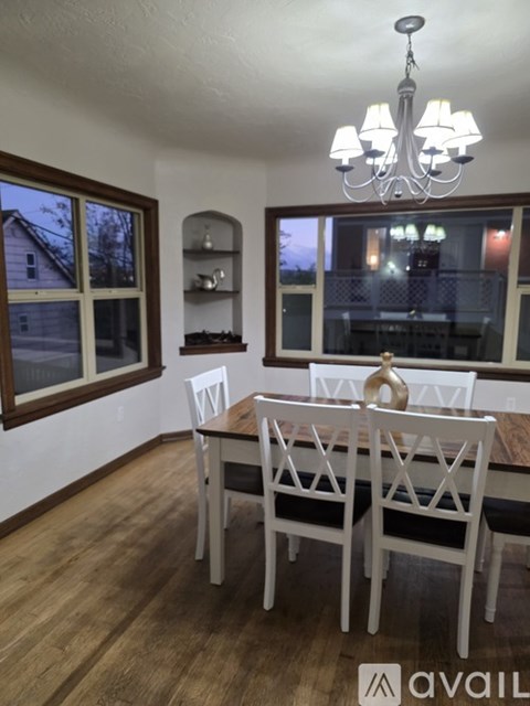 A dining room with a wooden table and chairs.