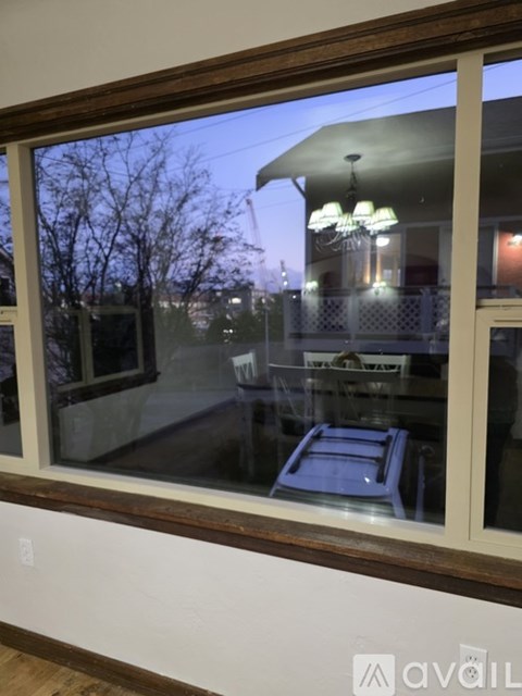 A window with a view of a house and trees outside.
