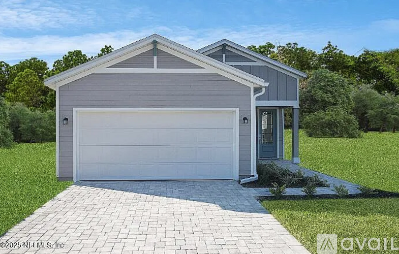 A modern house with a garage door and a driveway.
