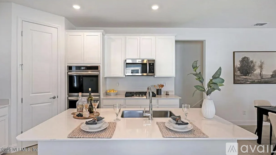 A modern kitchen with white cabinets and appliances.