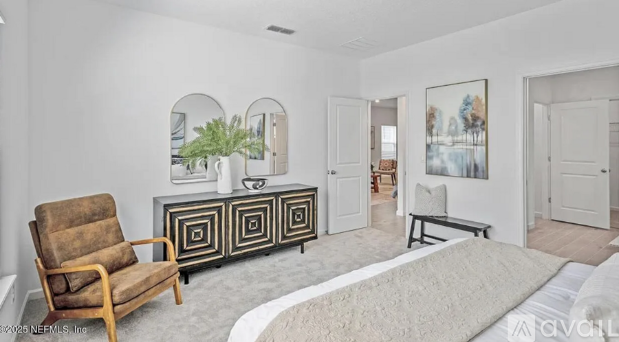 A living room with a brown chair, a white rug, and a painting on the wall.