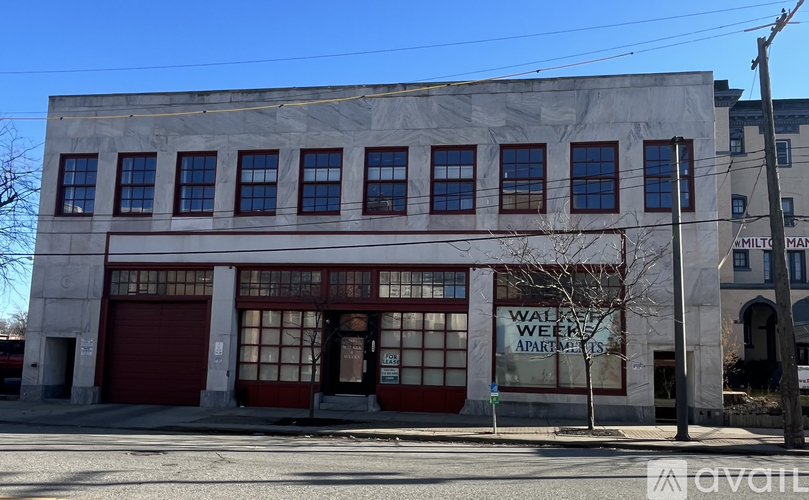 A large building with a red garage door and a sign that says "Walnut Weeks Apartments".
