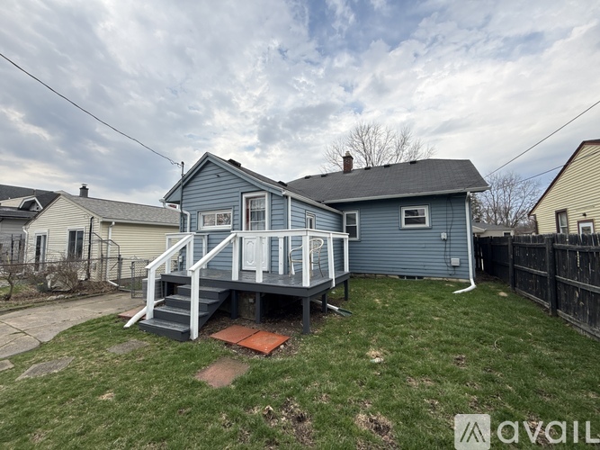 A blue house with a deck and a fence.