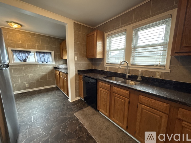 A kitchen with wooden cabinets and a black countertop.