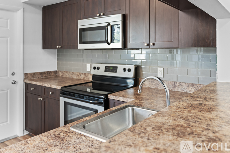 A kitchen with brown cabinets and a granite countertop.
