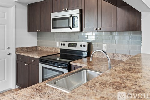 A kitchen with brown cabinets and a granite countertop.