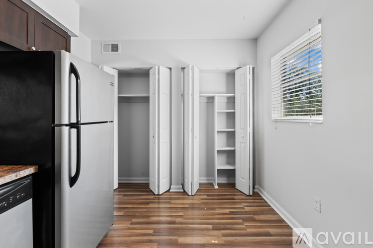 A kitchen with a black fridge and white cabinets.