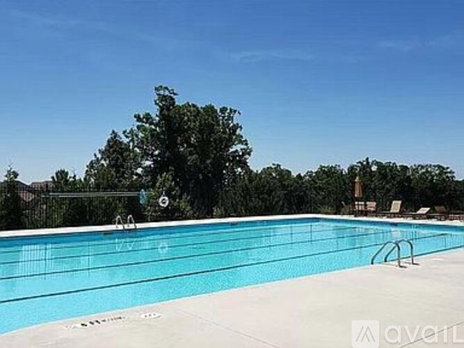 A large outdoor swimming pool surrounded by trees.