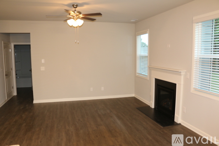 A living room with a fireplace and a ceiling fan.