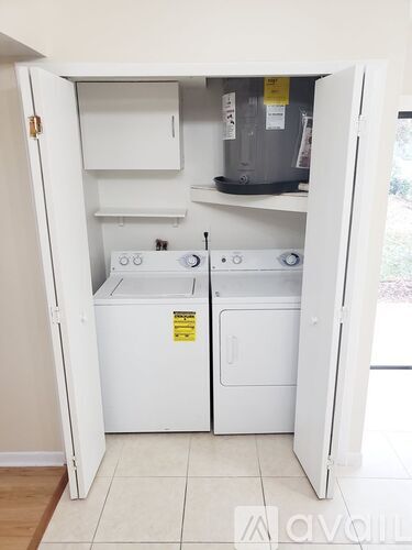 A small white kitchen with a dishwasher and a washing machine.