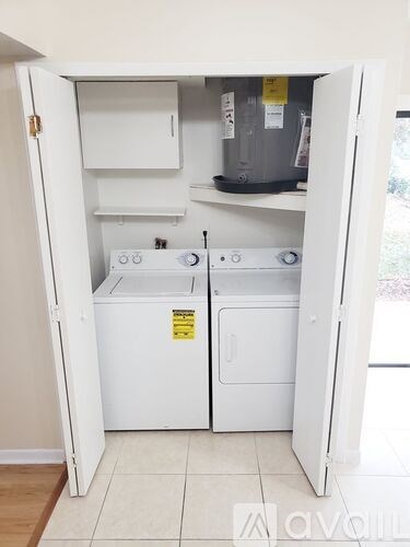 A small white kitchen with a dishwasher and a washing machine.
