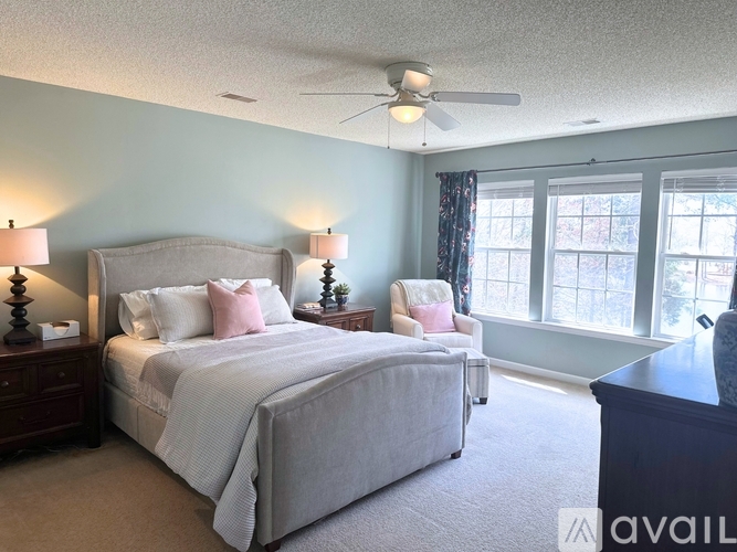 A bedroom with a large bed and a ceiling fan.