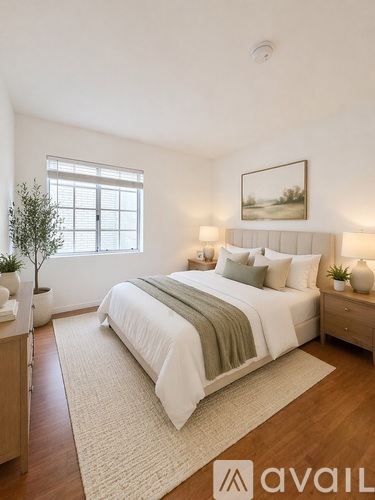 A bedroom with a large bed and a painting on the wall.