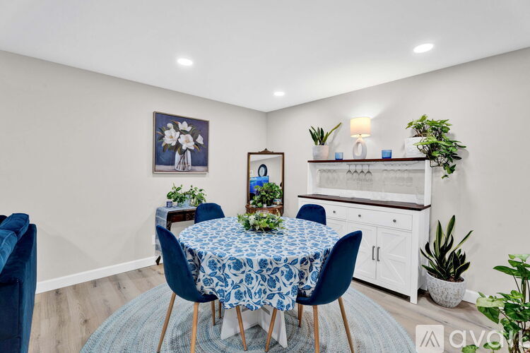 A dining room with a round table and blue chairs.