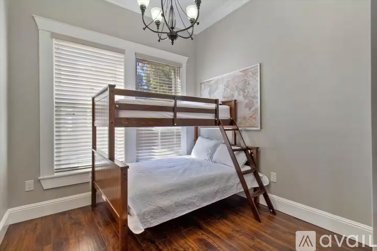 A bedroom with a wooden bunk bed and a chandelier.