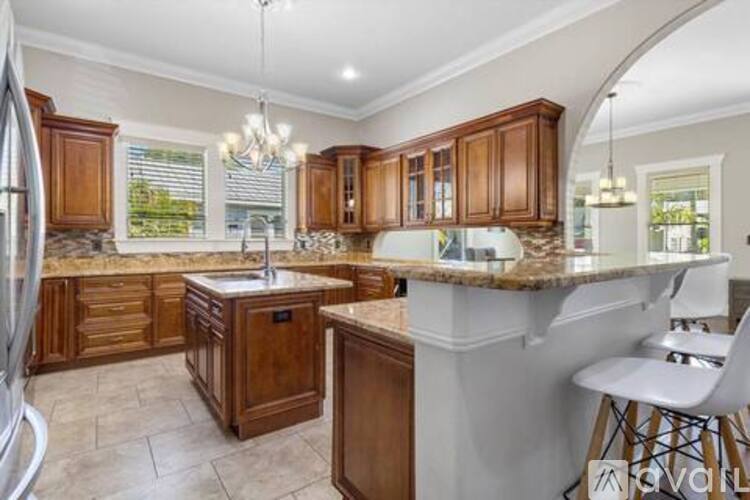 A kitchen with wooden cabinets and a marble countertop.