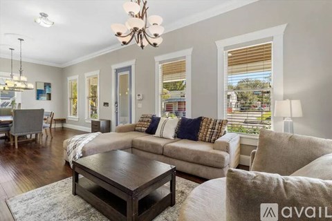 A living room with a brown coffee table and a grey couch with a white throw pillow.