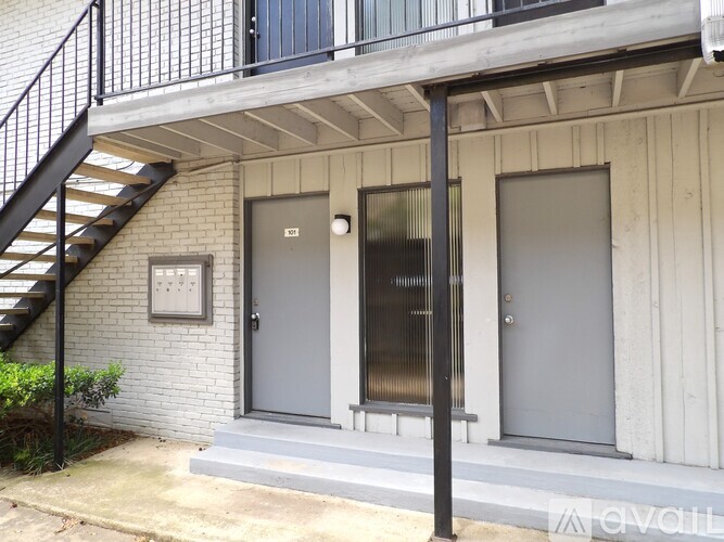 A house with a grey door and a black railing.