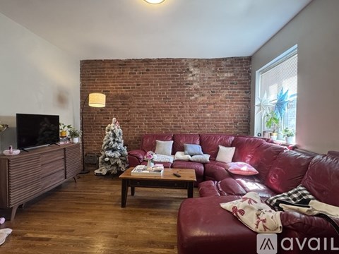 A living room with a red couch and a wooden coffee table.