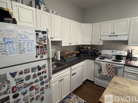 A white fridge with magnets and a chart on it in a kitchen.