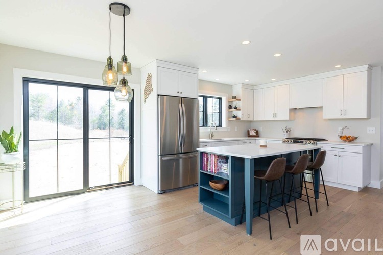 A kitchen with a large island and a refrigerator.