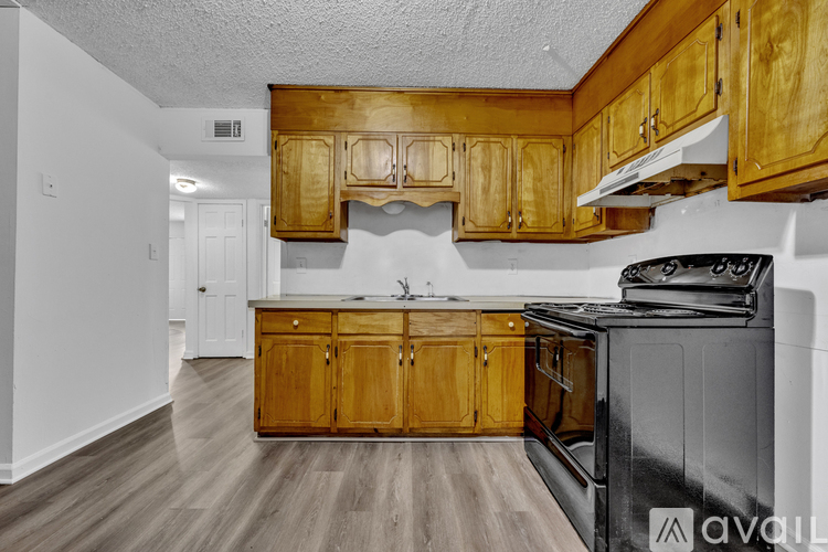 A kitchen with wooden cabinets and a black stove top oven.
