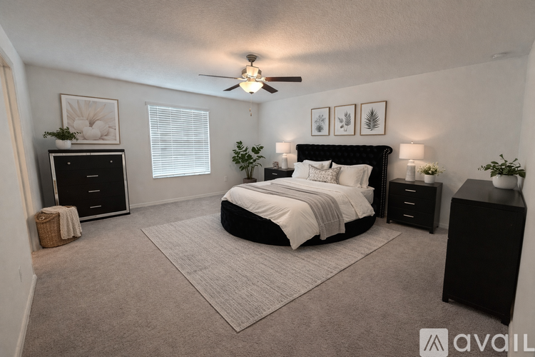 A bedroom with a large bed, a dresser, and a ceiling fan.