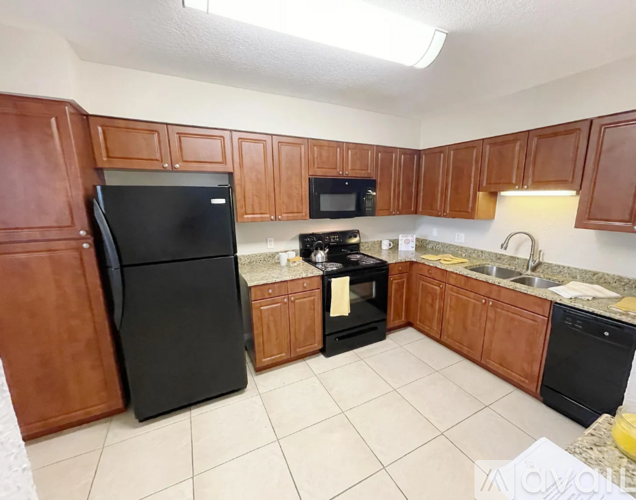 A kitchen with black appliances and wooden cabinets.