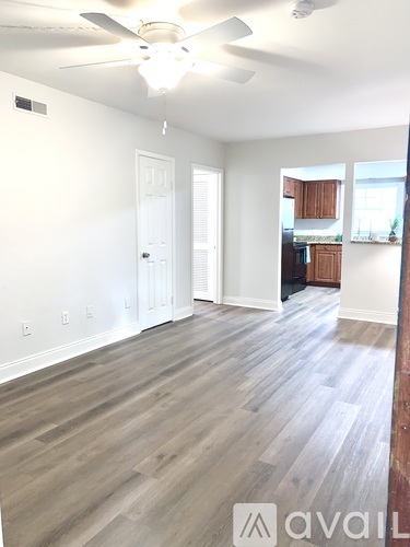 A room with a ceiling fan and wooden flooring.