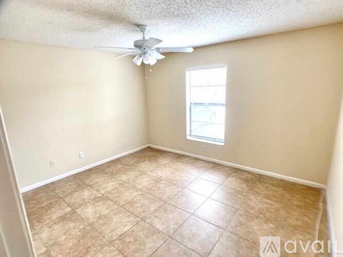 A room with a ceiling fan and a window.