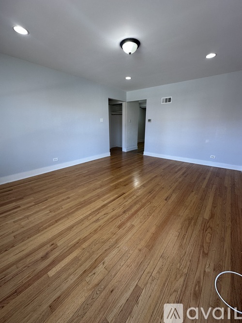 A room with wooden flooring and a white wall.