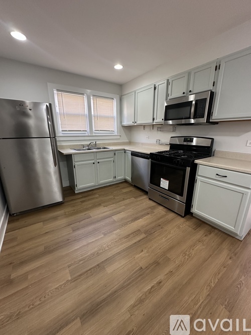 A kitchen with wooden floors and stainless steel appliances.