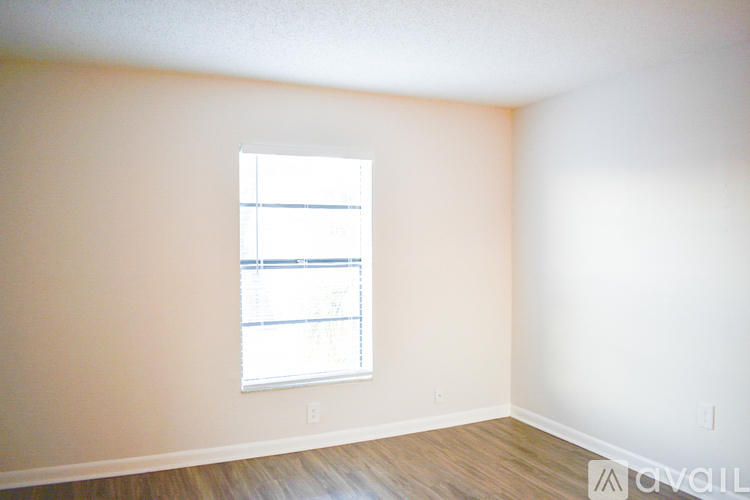 A room with a window and wooden flooring.