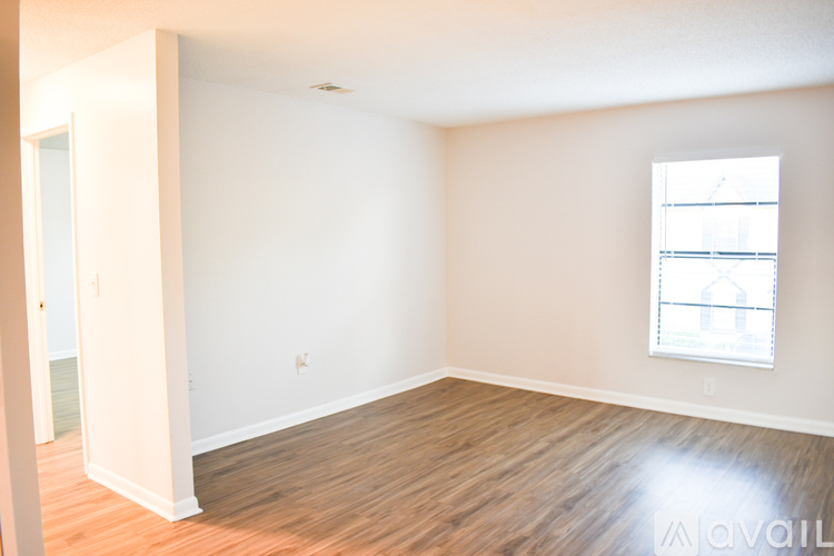 A room with a window and wooden flooring is available for rent.