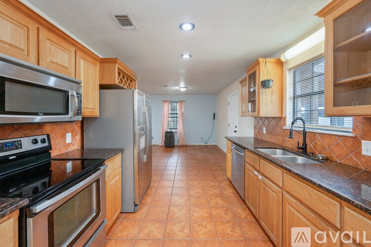 A kitchen with wooden cabinets and a black stove top oven.