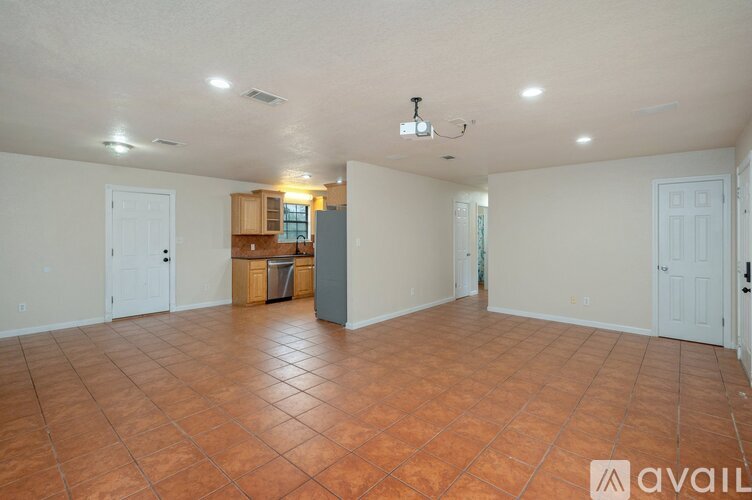 A spacious room with tile flooring and white walls.