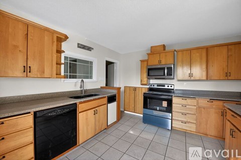A kitchen with wooden cabinets and a black stove top oven.