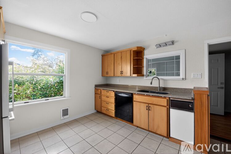 A kitchen with wooden cabinets and a white dishwasher.