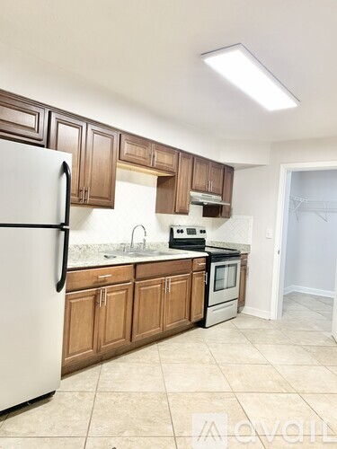 A kitchen with wooden cabinets and a white refrigerator.
