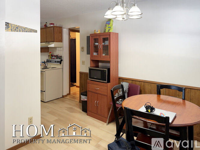 A kitchen with wooden cabinets and a dining table with chairs.