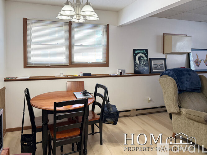 A dining room with a wooden table and chairs.