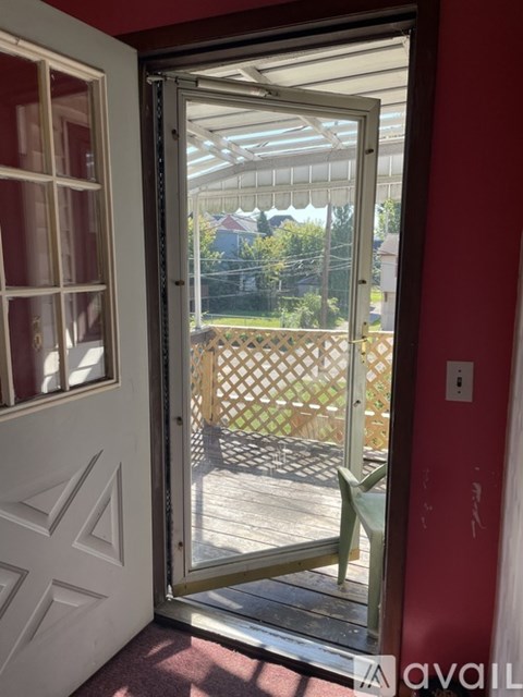 A room with a carpeted floor and a window with curtains.