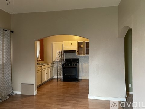 A kitchen with a black oven and wooden floors.