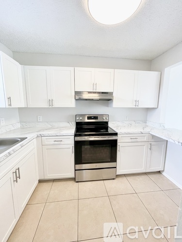 A kitchen with white cabinets and a stainless steel oven.